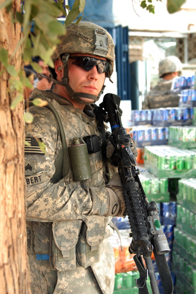 BAGHDAD - Sgt. Jordan Talbert, a Washington, Ind., native and a military policeman team leader assigned to the 300th MP Company, 91st MP Battalion, 8th MP Brigade, peeks around a tree while providing security during a joint patrol at Kessler...