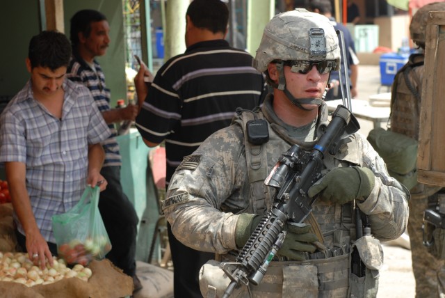 BAGHDAD - Cpl. Brian Shipway, a native of Keyser, W.Va., a military policeman team leader assigned to the 300th MP Company, 91st MP Battalion, 8th MP Brigade, provides security during a joint patrol at Kessler "White Rose" Market here, May 20....