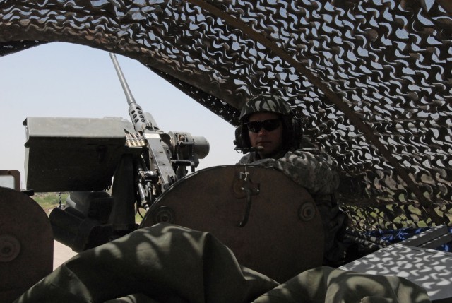 CAMP LIBERTY, Iraq - Sgt. A.J. Floyd, of Erie, Pa., a Soldier with 2nd Battalion, 112th Infantry Regiment, 56th Stryker Brigade Combat Team, pulls security from the gunner's hatch of a Stryker vehicle, May 19, while dismounted troops met with Iraqi A...