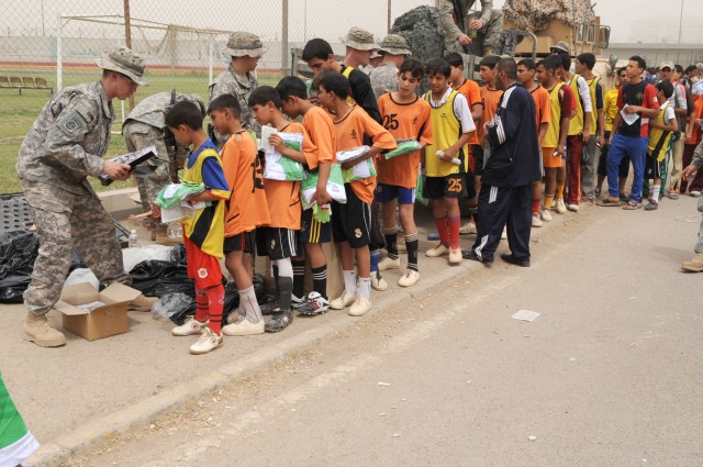 BAGHDAD - Paratroopers assigned to the Headquarters and Headquarters Company, 3rd Brigade Combat Team, 82nd Airborne Division, Multi-National Division - Baghdad, hand out soccer equipment to Iraqi children at Shaab Stadium, May 22, in the Rusafa dist...