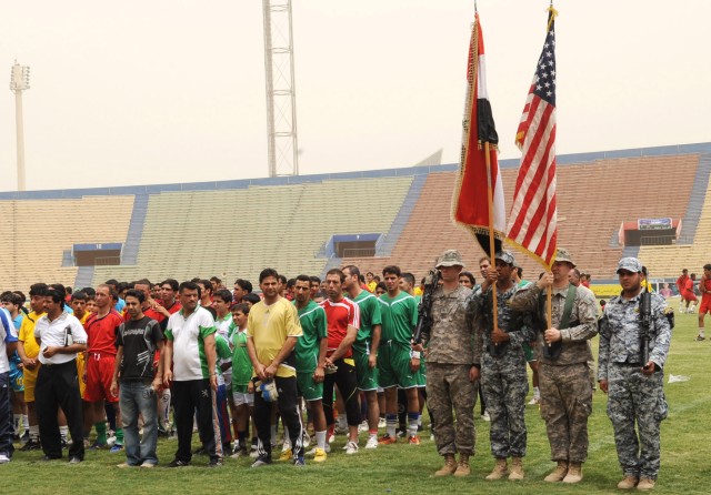 BAGHDAD - The Combined forces honor guard presents the national colors of Iraq and the United States as participates stand in formation during the playing of the national anthems for both nations during the opening ceremony of the FC Unity tournament...