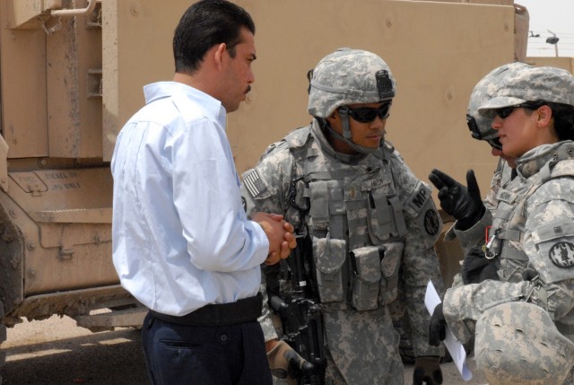 BAGHDAD - Second Lt. Romeo Hizon (center), of El Paso, Texas, a military policeman assigned to the 591st Military Police Company, 93rd MP Battalion, 8th MP Brigade, listens intently as an interpreter translates the issues of a policeman of the Abu...