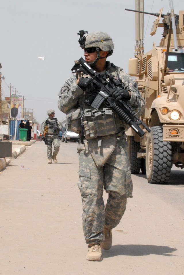 BAGHDAD - Staff Sgt. Jonathan Romero, from San Antonio, a military policeman assigned to the 591st Military Police Company, 93rd MP Battalion, 8th MP Brigade, keeps his guard up while dismounted during a patrol in the Abu Ghraib district, here,...