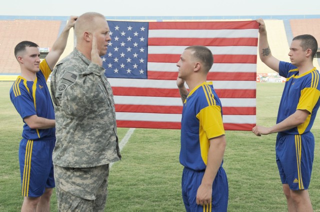 BAGHDAD - Col. Timothy McGuire (left), of Alamo, Calif., commander of the 3rd Brigade Combat Team, 82nd Airborne Division, Multi-National Division-Baghdad, administers the oath of reenlistment to Spc. John MacMurray at halftime of the combined...