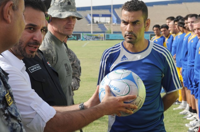 BAGHDAD - Yamam Nabeel (left), chief executive of FC Unity, holds a soccer ball donated by the "Kick for Nick" organization during the beginning of the final game of the combined forces tournament at Shaab Stadium May 23 in the Rusafa district of...