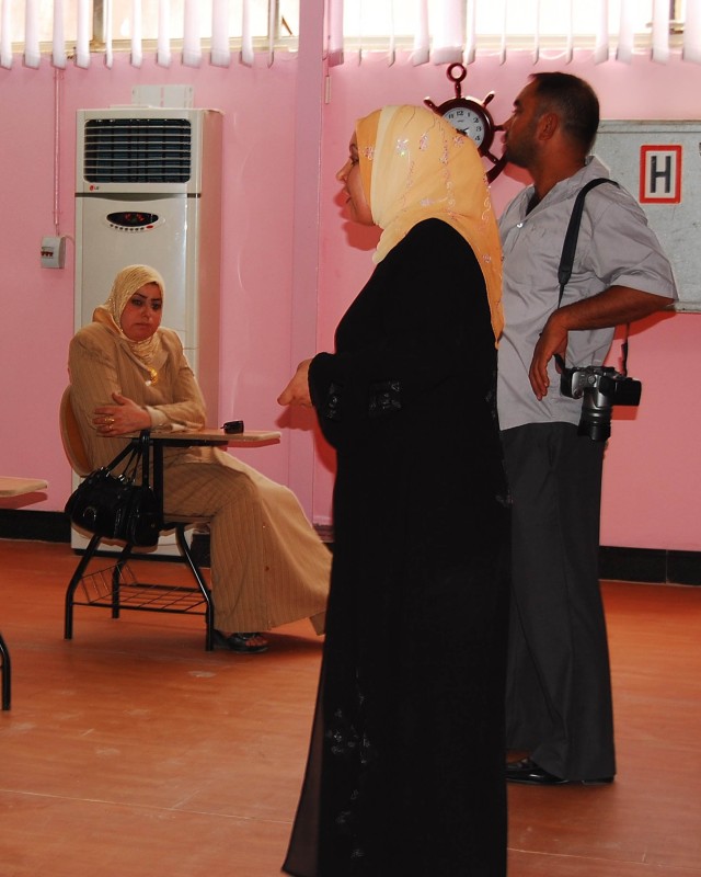 BAGHDAD- Prospective students and local media at the Mahmudiyah Sewing and Beauty Votech School learn more about business oportunities for local women during the school's opening ceremony, May 21.  The school is located on the grounds of the Ready...