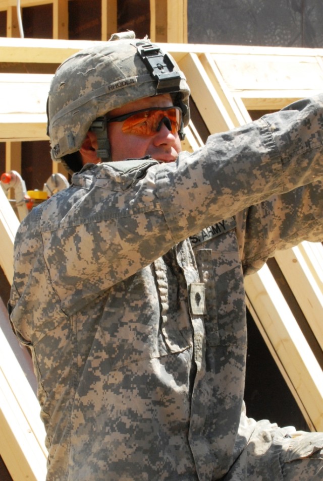 BAGHDAD - Spc. Jason Rhodes, of San Bernardino, Calif., helps fellow team mates of Company B, 46th Engineer Combat Battalion (Heavy), 225th Engineer Brigade, May 18. Rhodes said that even though the working conditions are tough, his team and...