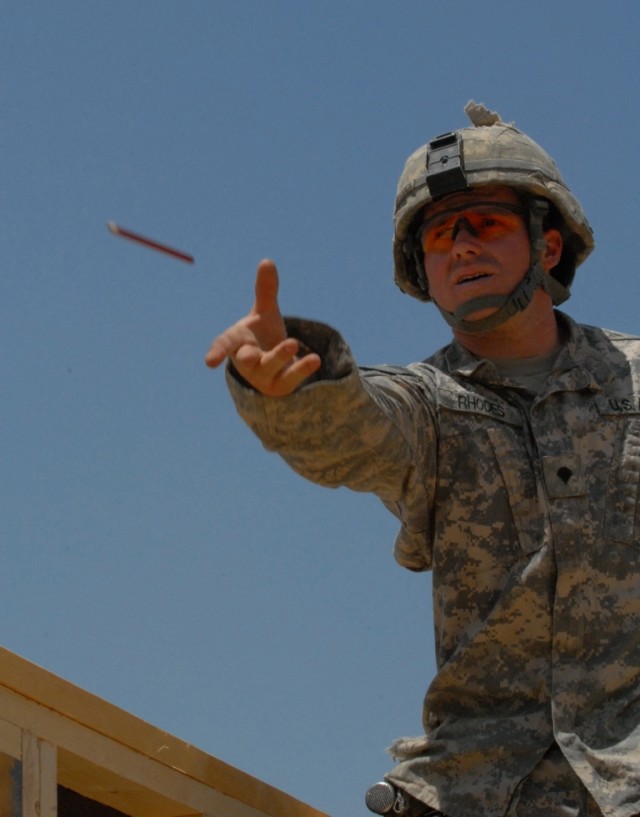 BAGHDAD - Spc. Jason Rhodes, of San Bernardino, Calif., tosses a pencil to a team mate on the site of a large expansion project at Combat Outpost Carver in southeastern Baghdad. As a specialist, Rhodes, a Company B, 46th Engineer Combat Battalion...