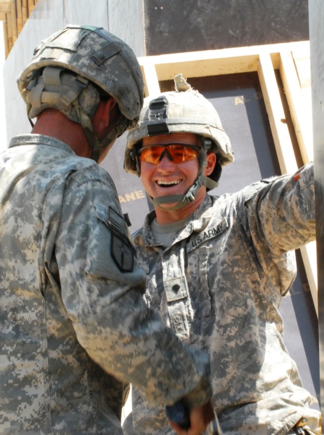 BAGHDAD – Spc. Jason Rhodes laughes with a fellow Company B, 46th Engineer Combat Battalion (Heavy), 225th Engineer Brigade Soldier while helping his team hold a wall in place, May 18.  “This is definitely a very good bond experience,”...