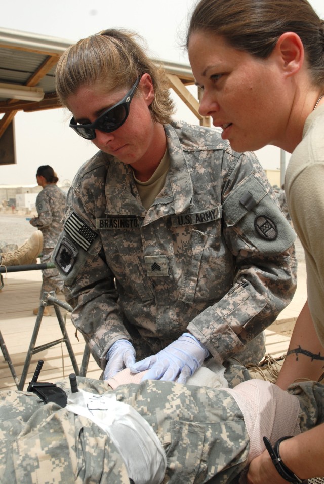 BAGHDAD - Sgt. Stephanie Brassington (left), of Jacksonville, N.C., and Staff Sgt. Jennifer Williams, of Fayetteville, N.C., treat a Soldier during a simulated indirect fire attack on Forward Operating Base Falcon in southern Baghdad, May 22. Brassin...