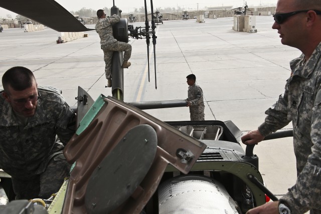 CAMP TAJI, Iraq-Technical inspectors from both the 1st Air Cavalry Brigade, 1st Cavalry Division, Mulit-National Division-Baghdad, and 4th Combat Aviation Brigade, 4th Infantry Division, complete a joint inspection of an AH-64D Apache attack helicopt...