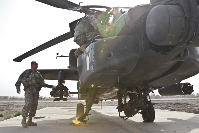 CAMP TAJI, Iraq-Chief Warrant Officer 4 Charlie Dodd (left), from Little Rock, Ark., an AH-64D Apache attack helicopter pilot in the 4th Combat Aviation Brigade, 4th Infatnry Division, Multi-National Division-Baghdad, conducts a final walk around of ...