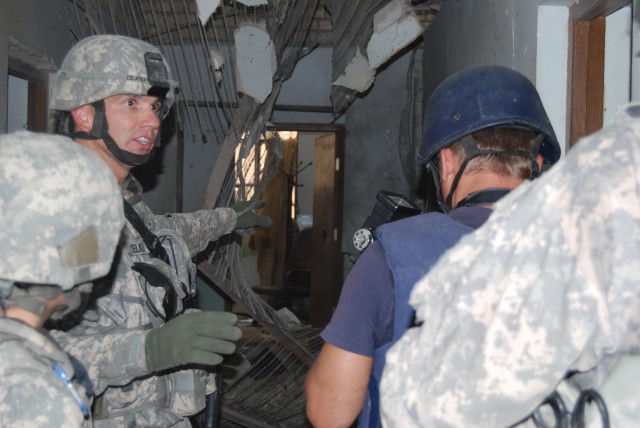 BAGHDAD - First Lt. Brian Celatka (left), the Karkh Iraqi Police Patrol Directorate Police Transition Team officer-in-charge, 93rd Military Police "War Eagle" Battalion, 8th MP Brigade, Multi-National Division-Baghdad, inspects the damage at the Ma'm...