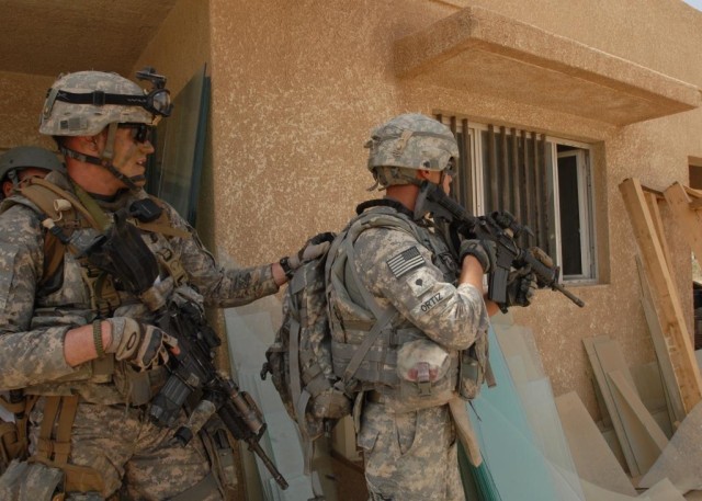 TAJI, Iraq - Staff Sgt. Paul Hanson (left) and Spec. Adam Ortiz, both of Erie, Pa, prepare to enter a building at the Nassir factory complex north of Camp Taji on May 24.  Both Soldiers are from Company B, 1st Battalion, 112th Infantry Regiment,...