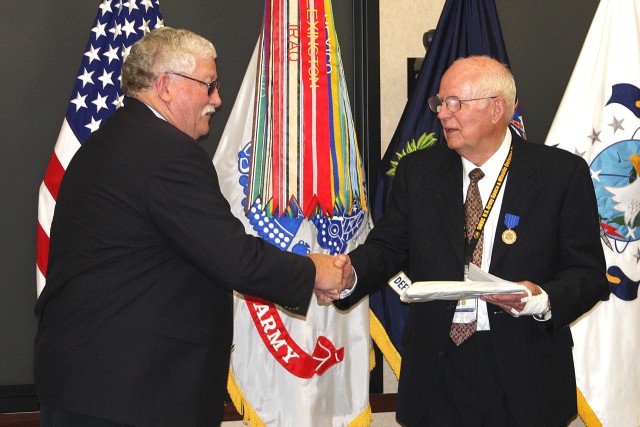 Leon Riley, general engineer, U.S. Army Space and Missile Defense Command/Army Forces Strategic Command, receives a gift and congratulations from John Johnson, senior program engineer, Raspet Flight Research Laboratory, Mississippi State University, ...