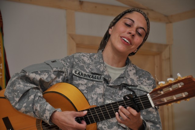 KANDAHAR AIRFIELD, Afghanistan - Annamaria Cardinalli, senior social scientist for Human Terrain Team and classically trained flamenco guitarist, sings and plays the hymn "Amazing Grace" during a chapel dedication service at Forward Operating Base...