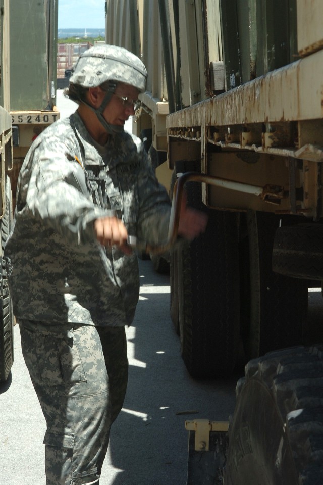 Sgt. Robin McBain, truck driver, 418th Transportation Company, raises the landing gear on a trailer containing equipment for turn-in June 3 at the 289th Quartermaster Company's motor pool. (U.S. Army photo by Staff Sgt. Rob Strain, 15th...