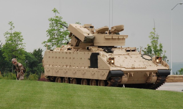 As part of an Army Birthday celebration at Fort Riley, a 1st Inf. Div. soldiers runs from an M2