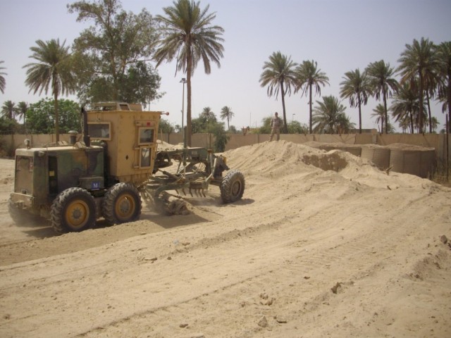 BAGHDAD - A heavy equipment operator from Equipment Platoon, 46th Engineer Combat Battalion (Heavy), serving with the 225th Engineer Brigade, uses a grader to spread sand and dirt from old Hescos barriers.  The sand was used to level out the ground a...