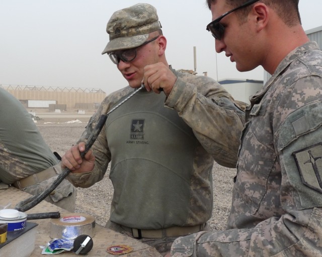 BAGHDAD - Sgt. Jason Peura (center), of Montgomery, Ill., a light-wheeled mechanic, 46th Engineer Combat Battalion (Heavy), 225th Engineer Brigade, uses skill, adhesives and his ingenuity to fix a broken brake line. "You have to know how to work...