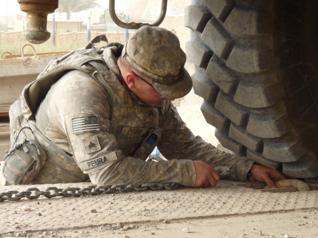 BAGHDAD - Sgt. Jason Peura, light-wheeled mechanic, 46th Engineer Combat Battalion (Heavy), 225th Engineer Brigade, prepares a crane to be tied down to a trailer after fixing the trailer's brakes. As one of only seven mechanics in the company,...