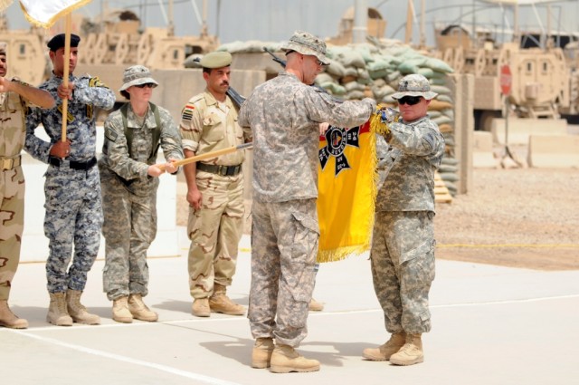 BAGHDAD - Brigade commander Col. Pat White (left) and Command Sgt. Maj. Michael Eyer, roll up their brigade's colors during the transfer of authority ceremony at forward operating base falcon, May 26. White and Eyer are both of 2nd Brigade Combat Tea...