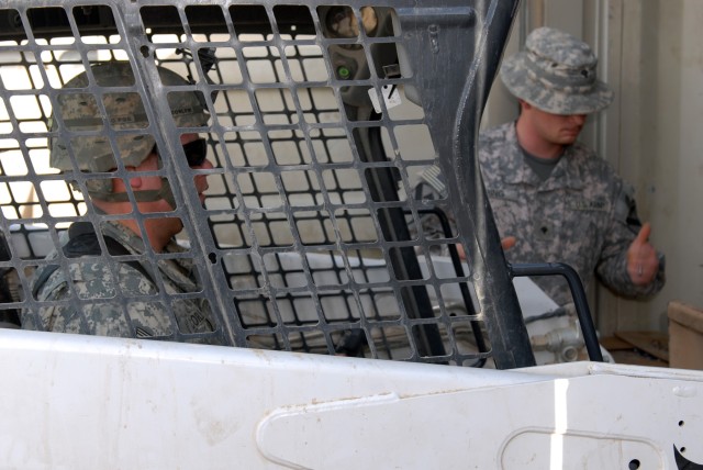 BAGHDAD - Pfc. Robert Corlew (left), a supply specialist from Muskegon, Mich., and Spc. Tyler Ring, an armorer, from Searcy, Ark., both assigned to Headquarters and Headquarters Company, 2nd Squadron, 5th Cavalry Regiment, 1st Brigade Combat Team,...