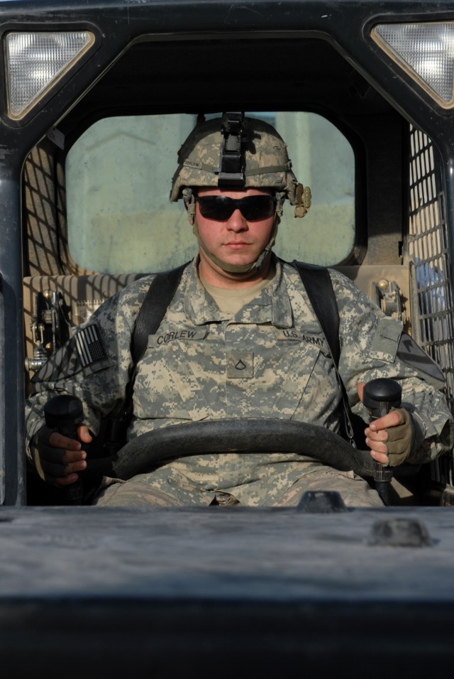 BAGHDAD - "Looking at the big picture - we're turning the country over and that's where it's headed," said Pfc. Robert Corlew, as he operates a forklift at Joint Security Station Sadr City, May 26. "It's a good thing that we're building a...