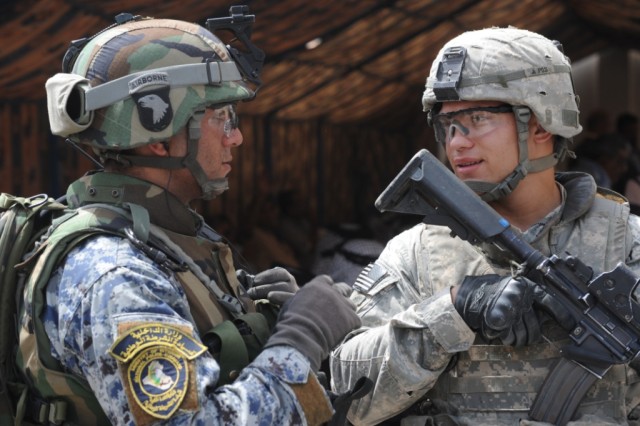 BAGHDAD - Sgt. Luis Zayas (right), of Cleveland, assigned to Headquarters and Headquarters Company, 2nd Battalion, 505th Parachute Infantry Regiment, 3rd Brigade Combat Team, 82nd Airborne Division, Multi-National Division-Baghdad, talks to a Nationa...