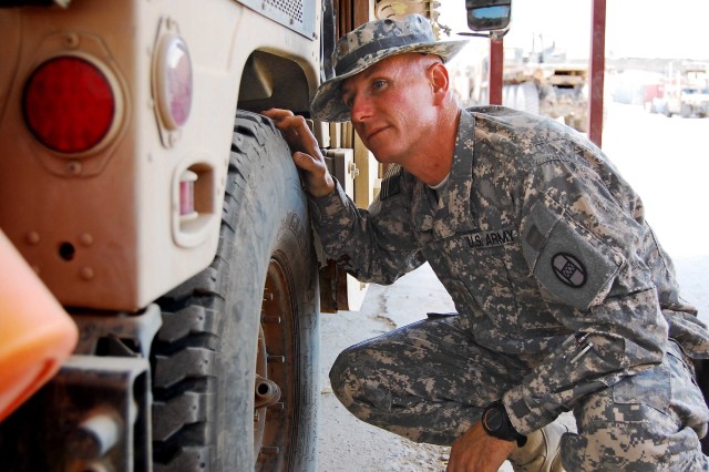 BAGHDAD - Second Lt. James Bowden, a mortar platoon leader with Headquarters and Headquarters Company, 120th Combined Arms Battalion, 30th Heavy Brigade Combat Team, Multi-National Division-Baghdad, inspects vehicle tires before going out on a...