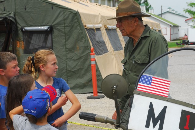 Army Pfc. (ret.) Bill Kreider, a participant in the 90th anniversary of the first transcontinental convoy and a resident of Carson City, Nev. talks to a group of children about military life during World War II here recently. The local event occurred...