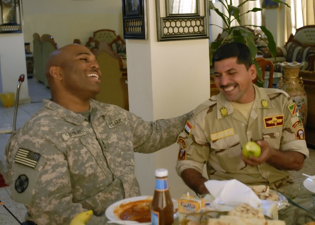 BAGHDAD - Master Sgt. Moty McKinney (left), a native of Saginaw, Mich., an advisor with the 24th Brigade, 6th Iraqi Army Division Military Training and Transition Team, shares a laugh with Command Sgt. Maj. Mahmud Lafta, 24th Bde. 6th I.A. Div., duri...