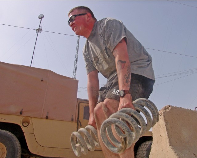 BAGHDAD- Spc. Daniel Beck, a radio operator with Company A, 120th Combined Arms Battalion, 30th Heavy Brigade Combat Team, Multi-National Division-Baghdad, lifts two 45-pound humvee springs as part of the Tabata cross fitness training program at...