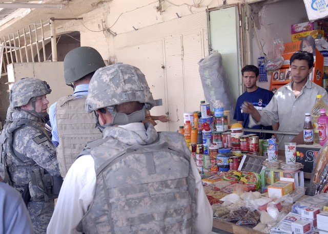 BAGHDAD - Lt. Gen Charles Jacoby (far left), commander, Multi-National Corps - Iraq, speaks with an Iraqi vendor at the new Abu Ghraib Market, May 28. Jacoby met with leaders in the 2nd Heavy Brigade Combat Team, 1st Infantry Division, Multi-National...