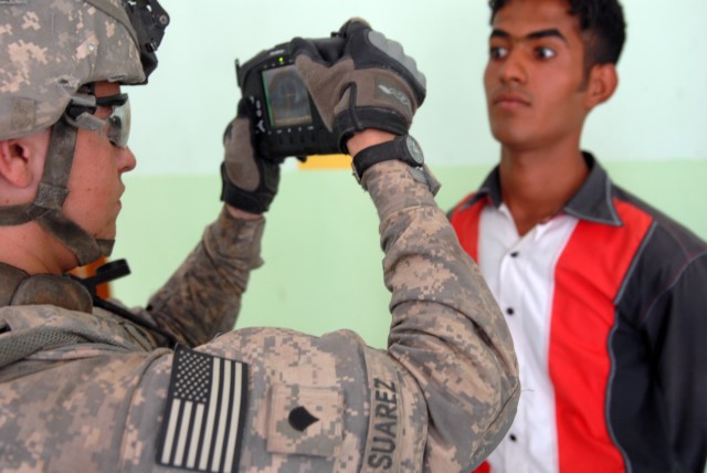 BAGHDAD - Spc. Edward Suarez, a tanker from Phelan, Calif., assigned to Company B, 2nd Battalion, 5th Cavalry Regiment, 1st Brigade Combat Team, 1st Cavalry Division, utilizes the Handheld Interagency Identity Detection Equipment (HIIDE) system to pu...
