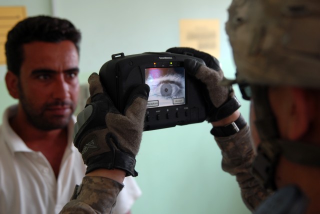 BAGHDAD - Spc. Edward Suarez, a tanker, assigned to Company B, 2nd Battalion, 5th Cavalry Regiment, 1st Brigade Combat Team, 1st Cavalry Division, performs a retinal scan with the Handheld Interagency Identity Detection Equipment (HIIDE) system for a...