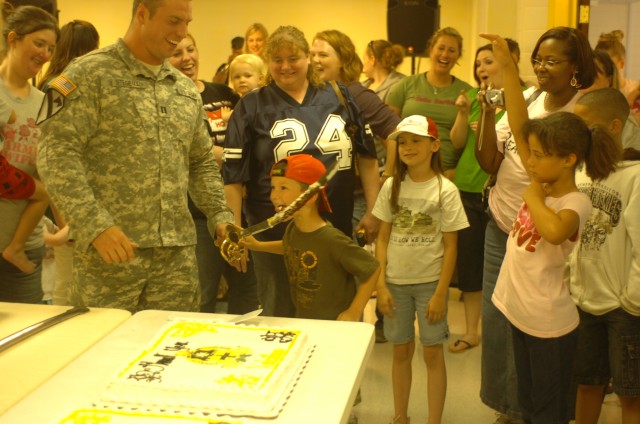 Capt. Tyler Stegeman, 1st Battalion, 5th Cavalry Regiment, 2nd Brigade Combat Team, 1st Cavalry Division Rear Detachment commander, of Jefferson City, Mo., allows Raymond August, 5, of Fort Hood, Texas, the chance to lick the icing off the...