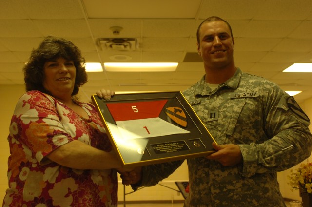 Capt. Tyler Stegeman, 1st Battalion, 5th Cavalry Regiment, 2nd Brigade Combat Team Rear, 1st Cavalry Division, Detachment commander, of Jefferson City, Mo., present an encased guidon, to Karen Cupples, from the Sears Teleserv Call Center in Round...