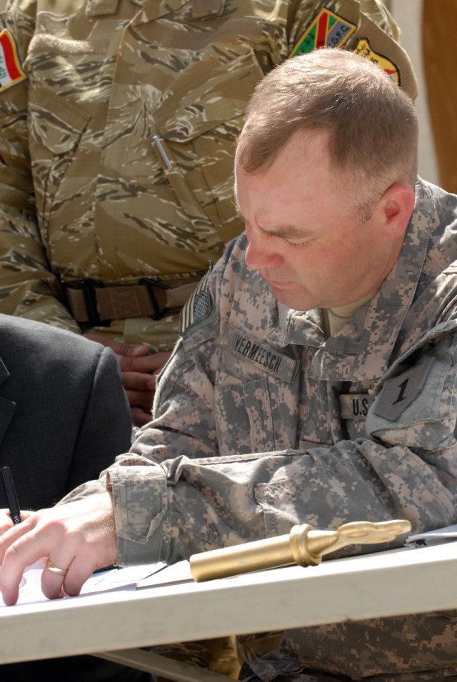 BAGHDAD - Lt. Col. John Vermeesch, a Roscommon, Mich., native and commander of 1st Battalion, 18th Infantry Regiment, 2nd Brigade Combat Team, 1st Infantry Division, signs the contract for the transfer of Joint Security Station Hurriyah, May 30. ...