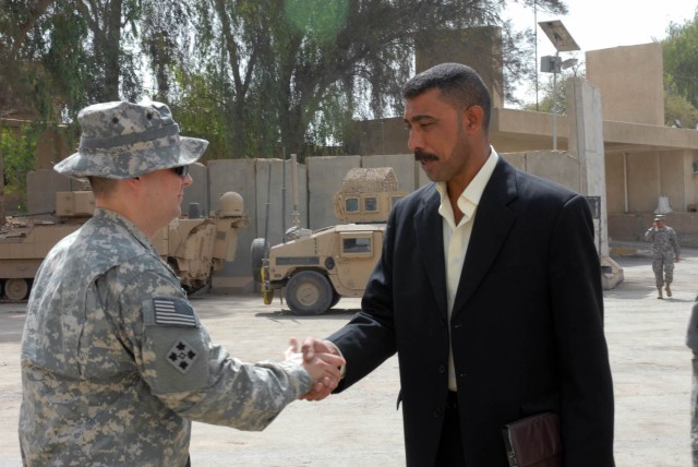 BAGHDAD -Maj. Tim Martin, of Commerce, Ga., the information operations officer for the 1st Brigade Combat Team, 1st Cavalry Division, greets a local leader of the Sons of Iraq to a conference at Joint Security Station War Eagle, May 29.  During...