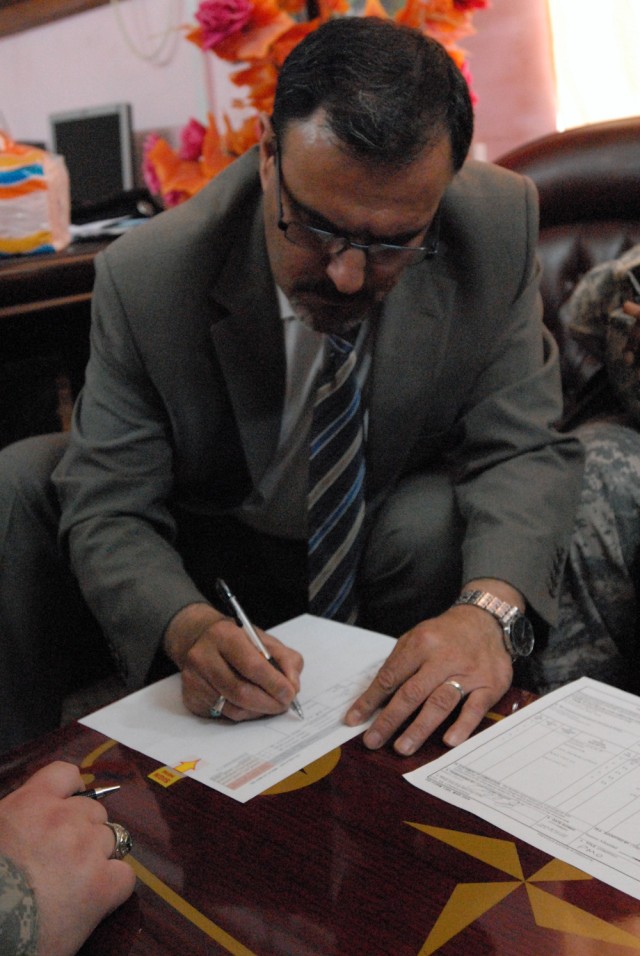 BAGHDAD- Mr. Sameer al Hadadd, the Office of the Prime Minister's representative, signs over Joint Security Station Adhamiyah to the Government of Iraq immediately after gaining responsibility from the U.S. forces, May 28. This is the beginning of...