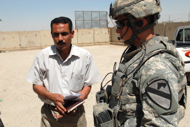 BAGHDAD - First Lt. Joe Zoretic (right), of Nashville, Tenn., a platoon leader assigned to Battery B, 1st Battalion, 82nd Field Artillery Regiment, 3rd Brigade Combat Team, 82nd Airborne Division, talks with a council member in the town of Jisr...