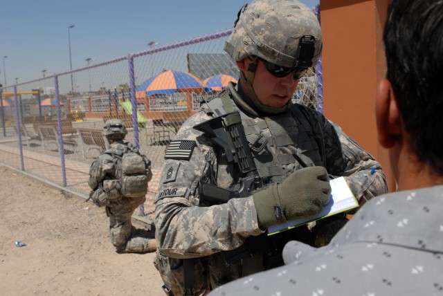 BAGHDAD - Master Sgt. Robert LaTour, a civil affairs team leader from Tacoma, Wash., assigned to Company B, 448th Civil Affairs Battalion, 1st Brigade Combat Team, 1st Cavalry Division, takes notes and asks questions from local community members...