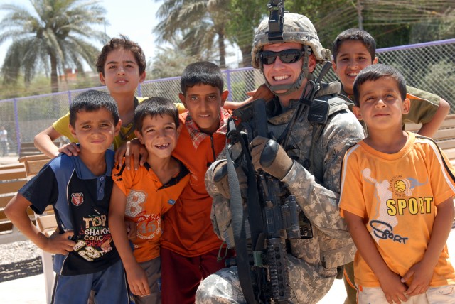 BAGHDAD - Seattle native, Staff Sgt. Matthew Bissell, a civil affairs team sergeant assigned to Company B, 448th Civil Affairs Battalion, 1st Brigade Combat Team, 1st Cavalry Division, takes a moment during a project assessment to smile with Iraqi...