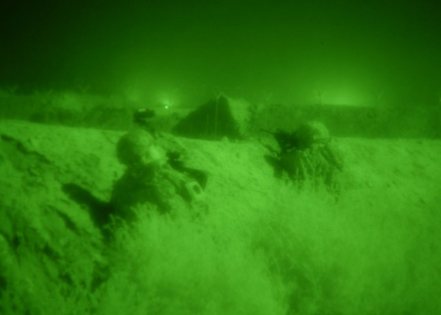 TAJI, Iraq - As seen through a night vision lens, two Soldiers from Company B, 1st Battalion, 112th Infantry Regiment, based in Corry, Pa., scan the Iraqi countryside north of Camp Taji in the early morning hours of May 31. The Pennsylvania...