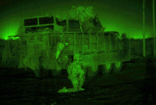 TAJI, Iraq - As seen through a night vision lens, Sgt. Ben Behringer, of Lake City, Pa., Company B, 1st Battalion, 112th Infantry Regiment, 56th Stryker Brigade Combat Team, scans the Iraqi countryside north of Camp Taji in the early morning...