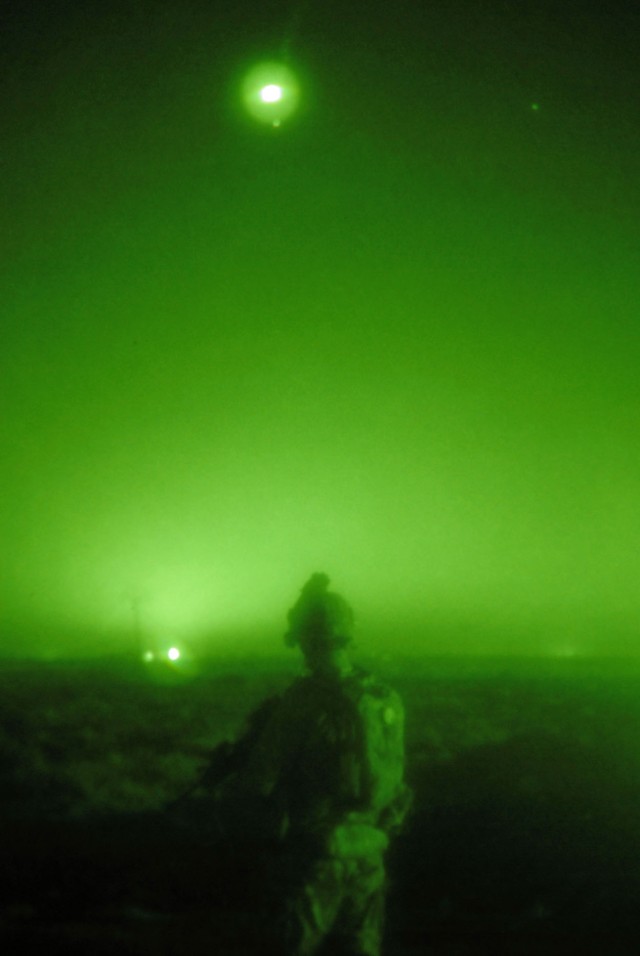 TAJI, Iraq - A Soldier from Company B, 1st Battalion, 112th Infantry Regiment, 56th Stryker Brigade Combat Team Soldier, scans the Iraqi countryside north of Camp Taji in the early morning hours, May 31, as an illumination artillery round descends...