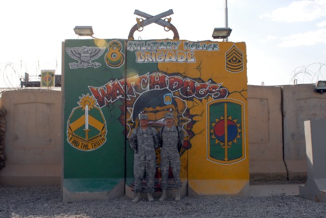 BAGHDAD- Spc. Vincente Oliver (left) and his father, Sgt. Thomas Krumpfer (right), both assigned to 267th Military Police Company, 93rd MP Battalion, 8th MP Brigade, Multi-National Division-Baghdad, stand in front of their brigade's headquarters on C...