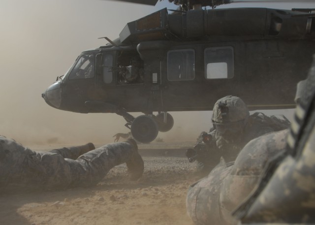 TAJI, Iraq - Staff Sgt. Craig Stevens (center), of Pottsville, Pa., with Headquarters and Headquarters Company, 1st Battalion, 112th Infantry Regiment, maneuvers through a cloud of dust to get into position between two other Soldiers, June 3,...