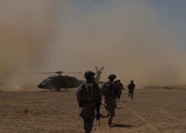 TAJI, Iraq - Soldiers of 1st Battalion, 112th Infantry Regiment, 56th Stryker Brigade Combat Team move toward a waiting UH-60 Blackhawk helicopter, June 3, to leave a search site in the Iraqi desert near Nubai. The Pennsylvania Guardsmen worked...